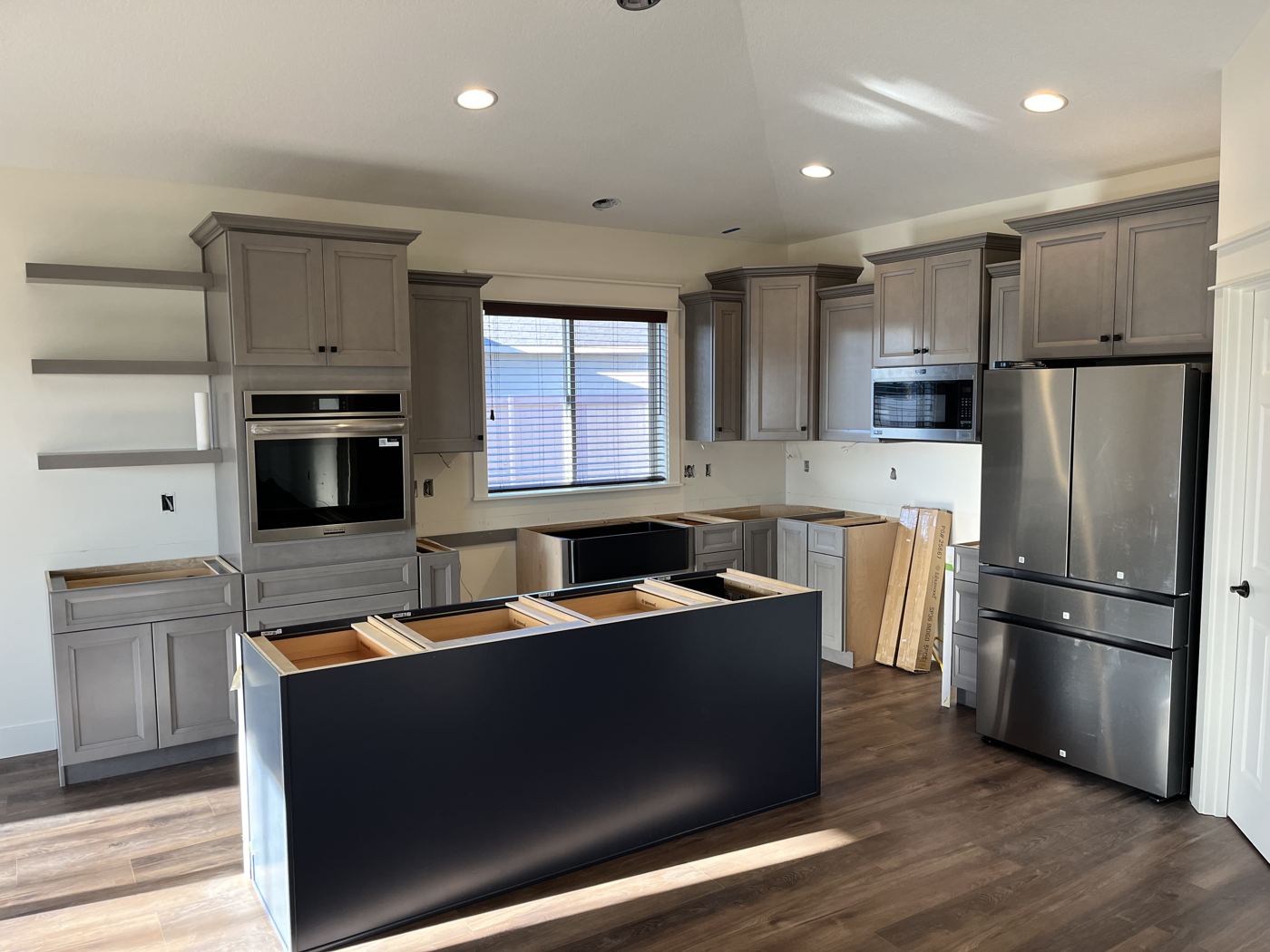 Gray cabinets going in, island base set before the top