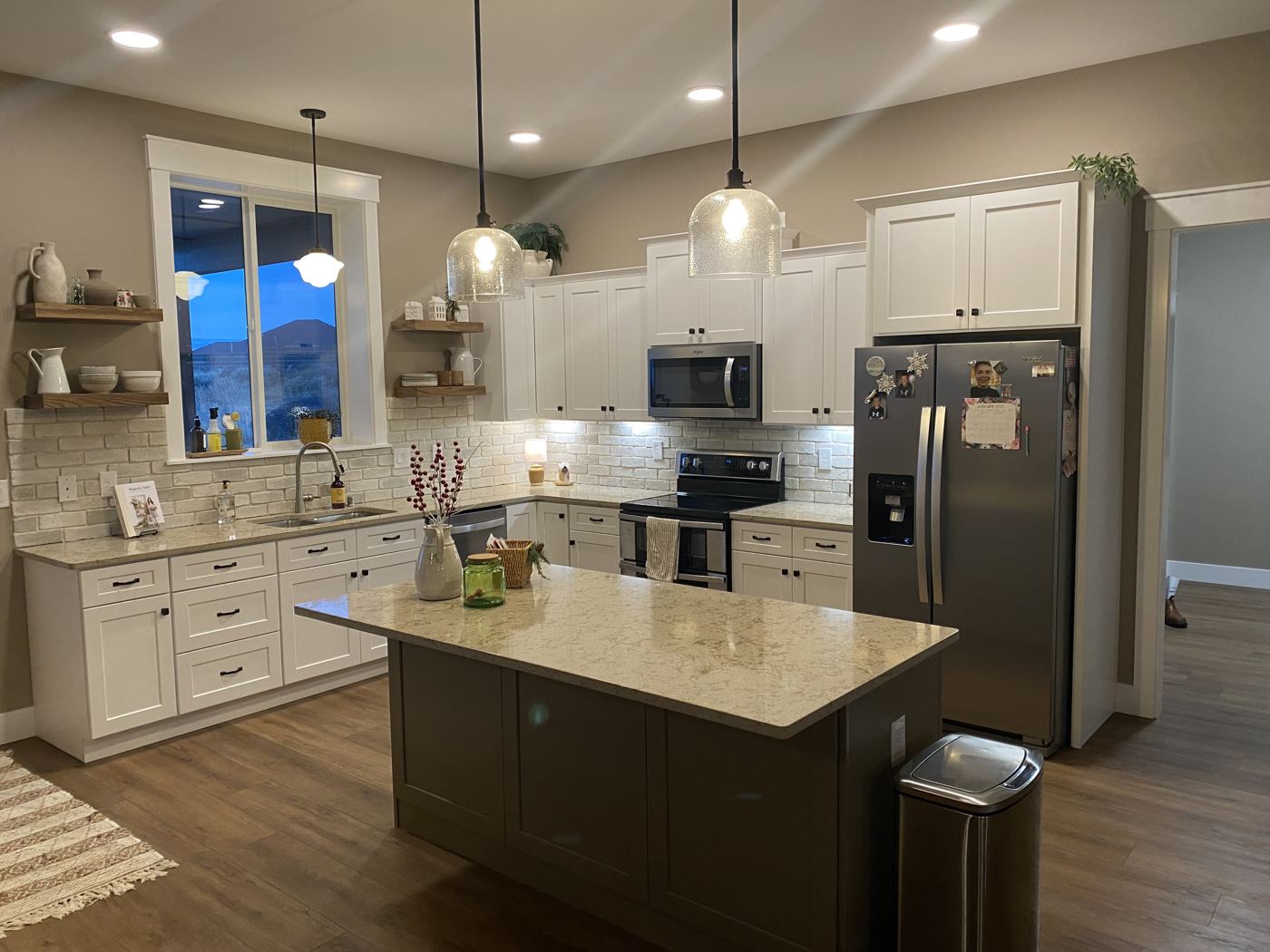 Kitchen with a dark island, stone top and pendant lights