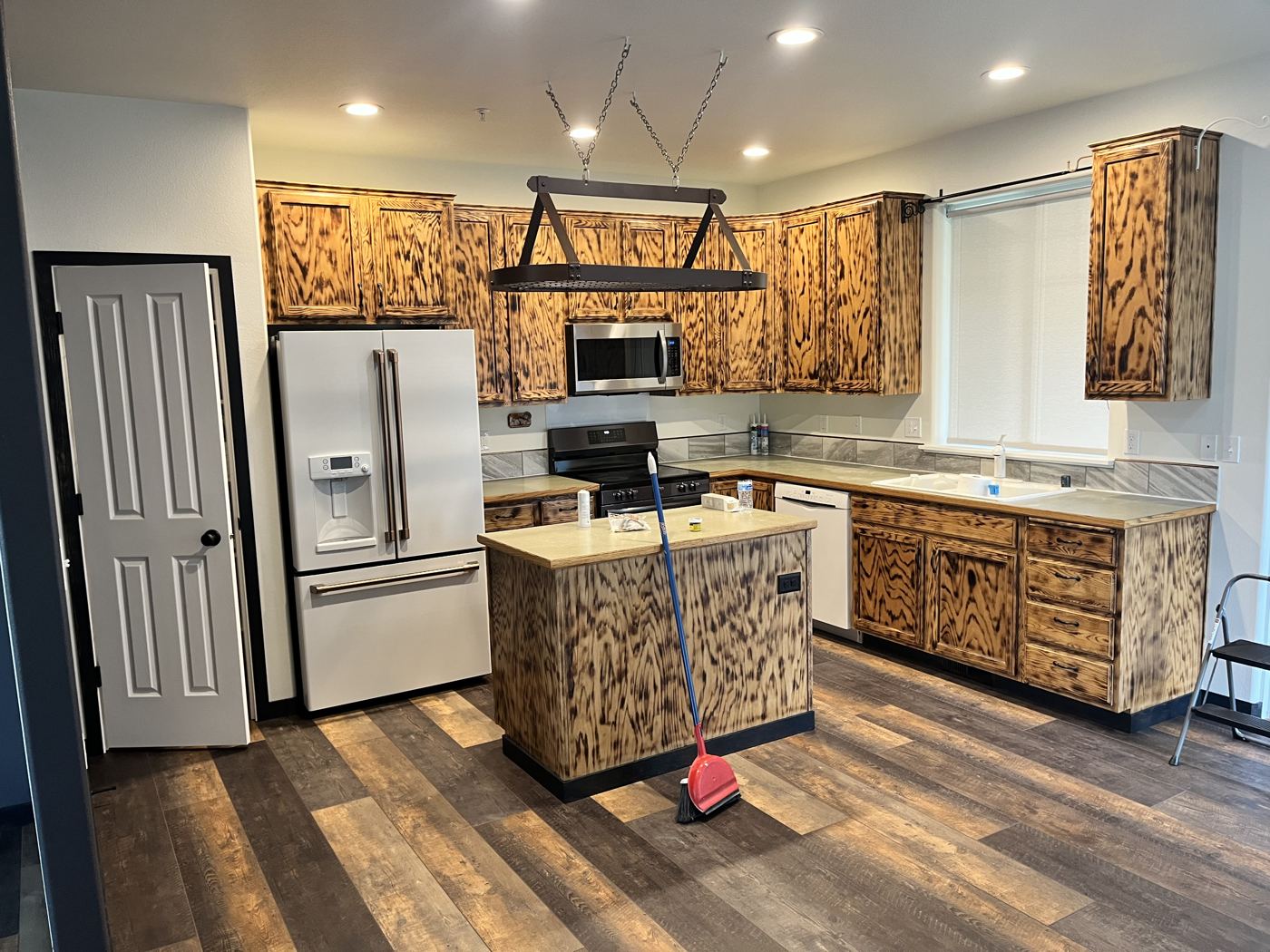 Kitchen with rustic torched wood cabinets and a matching island