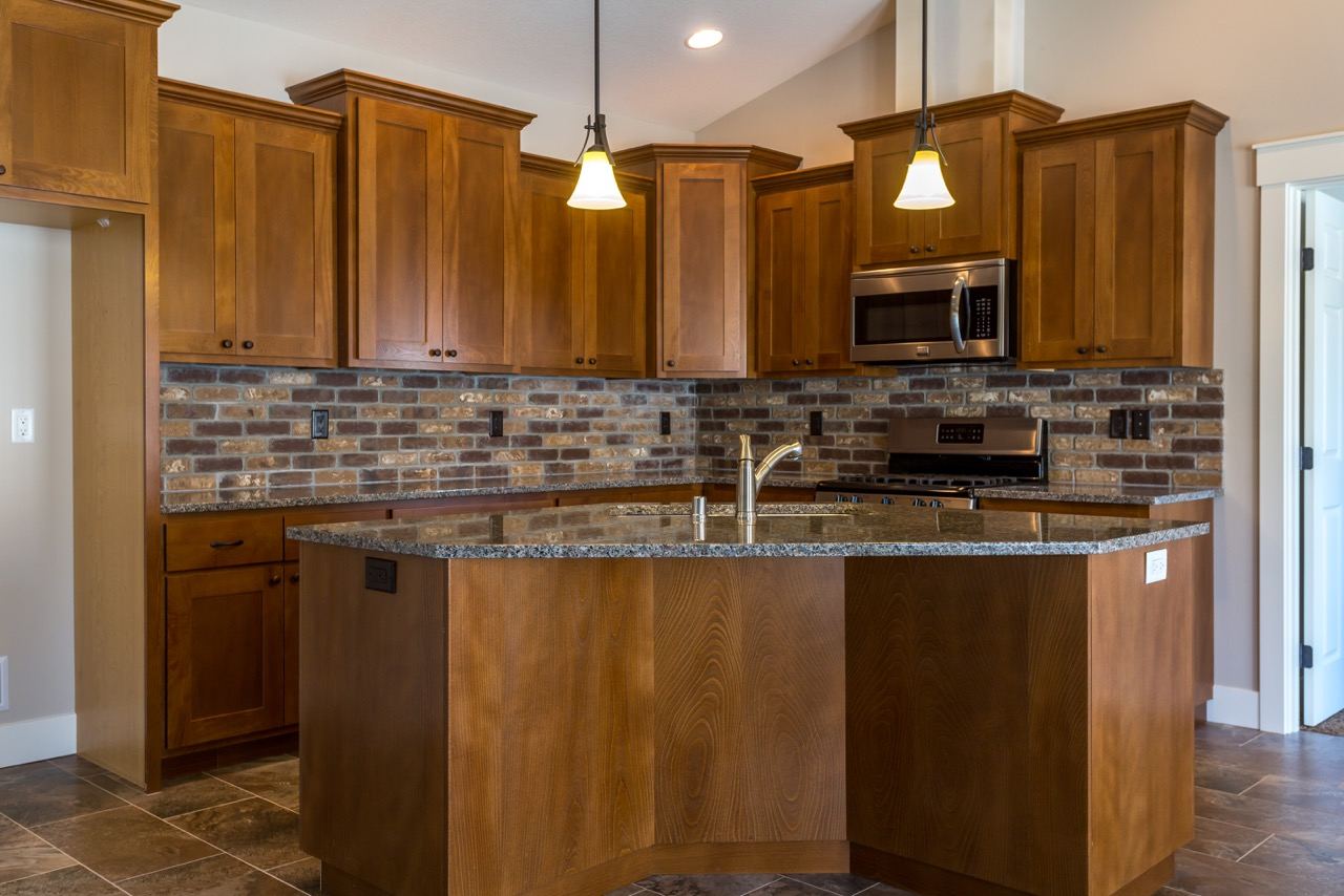 Stained shaker kitchen with an angled granite island